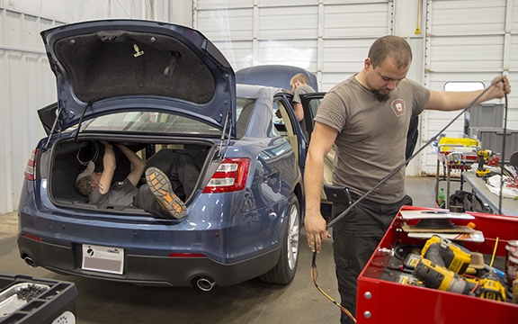 Staff installing equipment in detective car